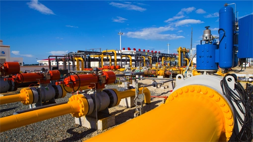 Gas processing plant with large yellow pipes.